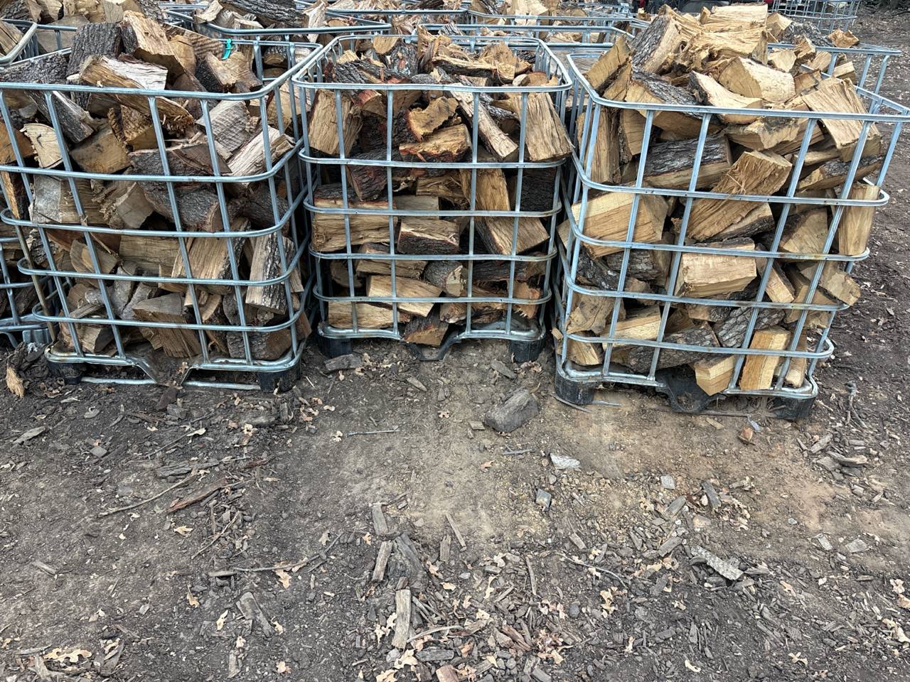 Bargain bins of shorter firewood pieces stacked in pickup cages